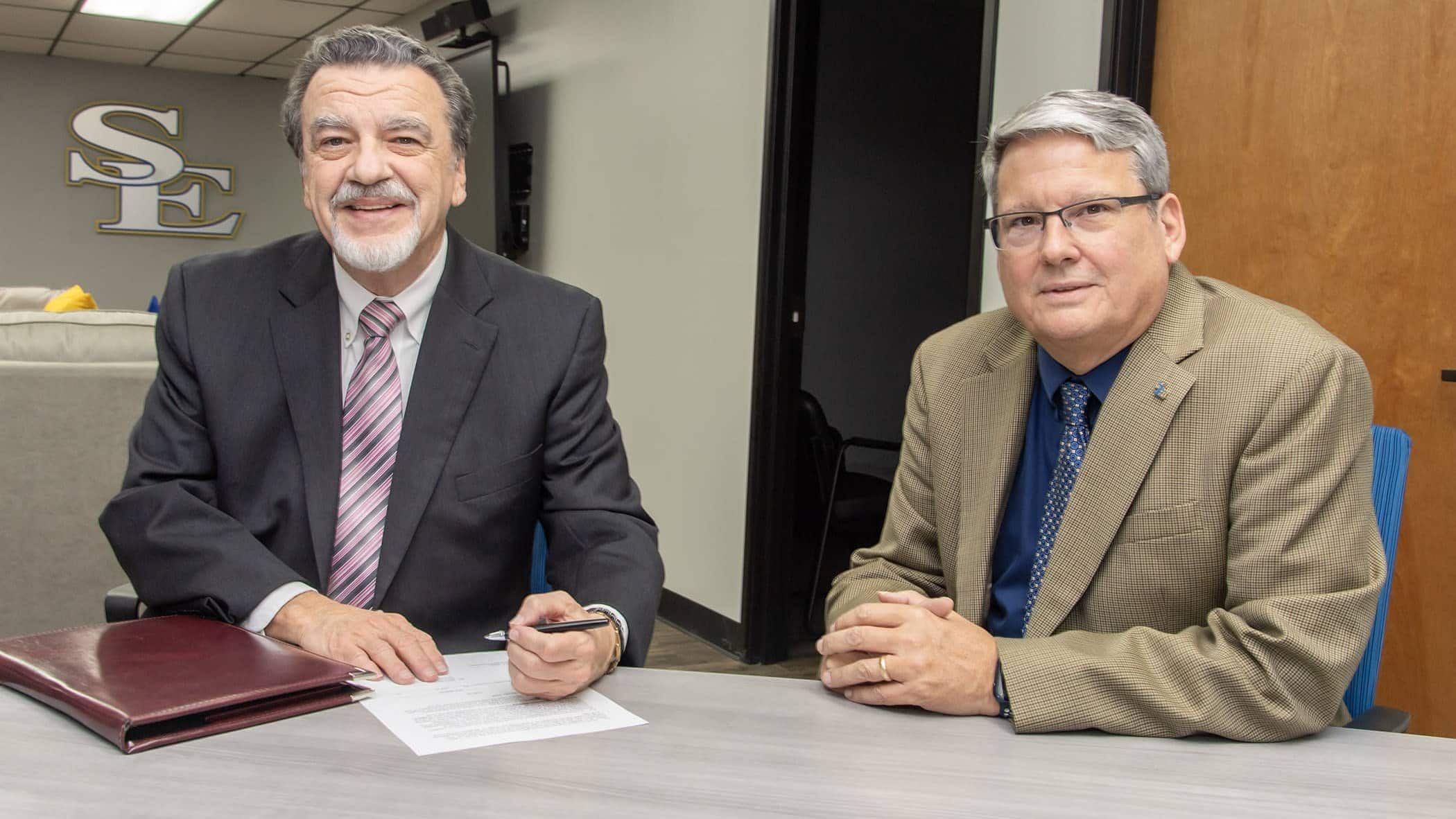 Joel Wellnitz signs the agreement to establish the Joel F. and Beverly Westheimer Wellnitz Scholarship Fund