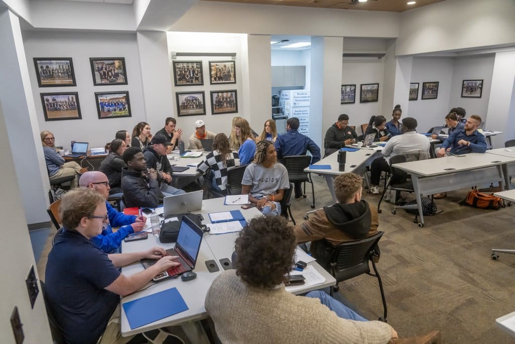 A group of students discussing things in a classroom