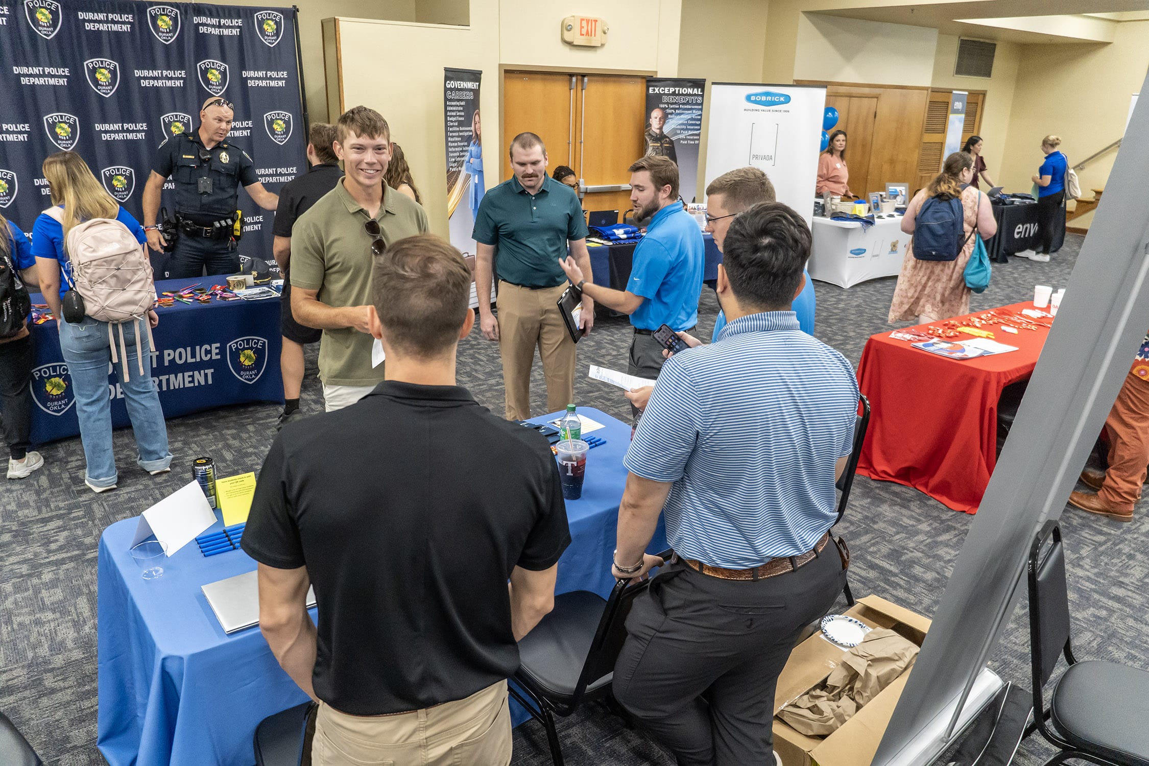 A group of Southeastern students speaking with a potential employer at a table at a career fair