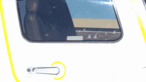 A shot panning from a smiling woman in sunglasses with her hair blowing in the wind to the SE logo on the front fuselage of an airplane