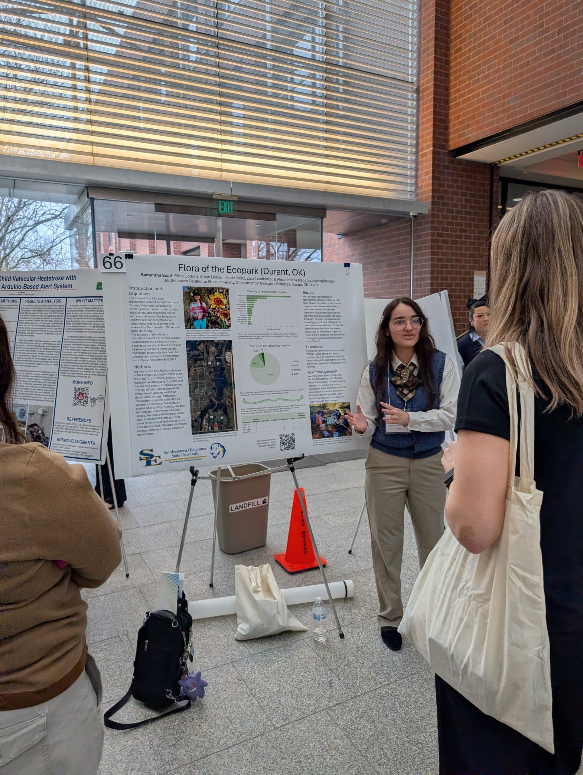 A woman speaking in front of a research poster