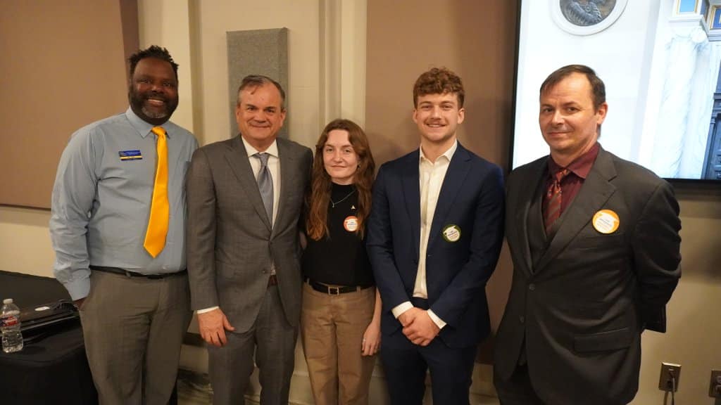 A group of five people posing together in formal attire.