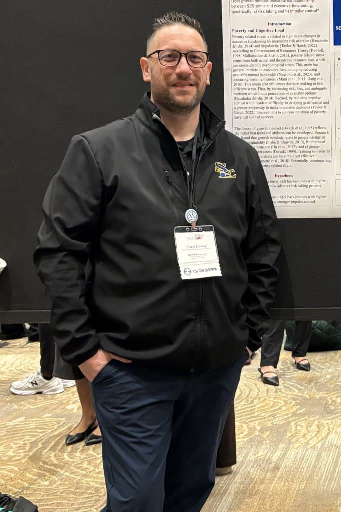A man standing in front of a research poster