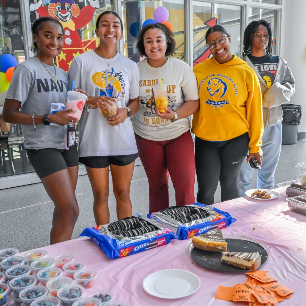 Students standing in a line smiling holding popcorn
